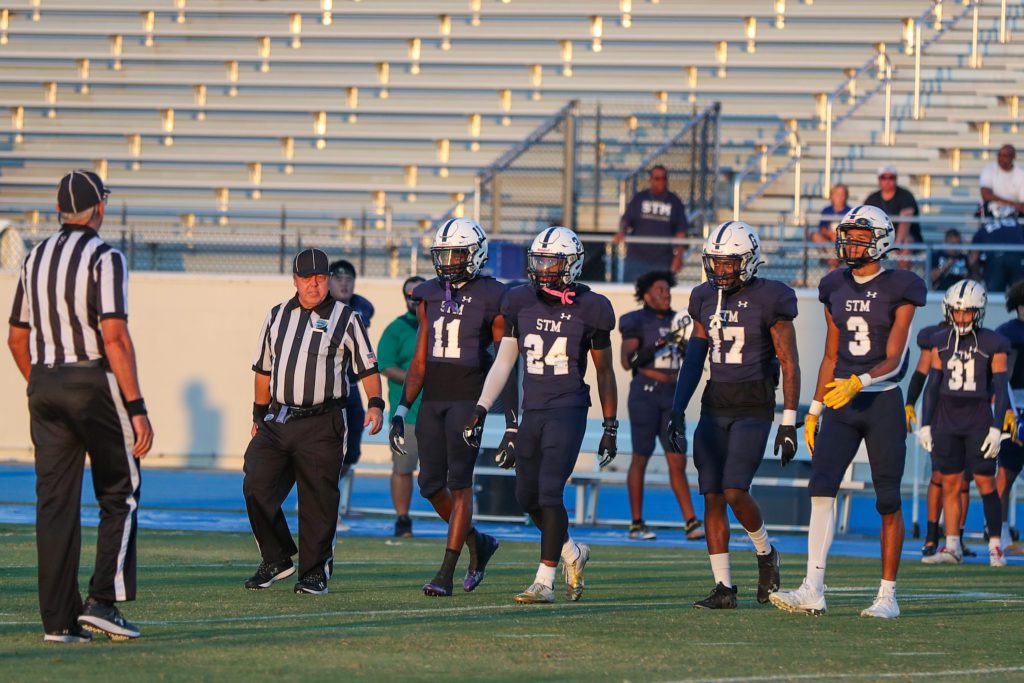 STM football players walking towards field