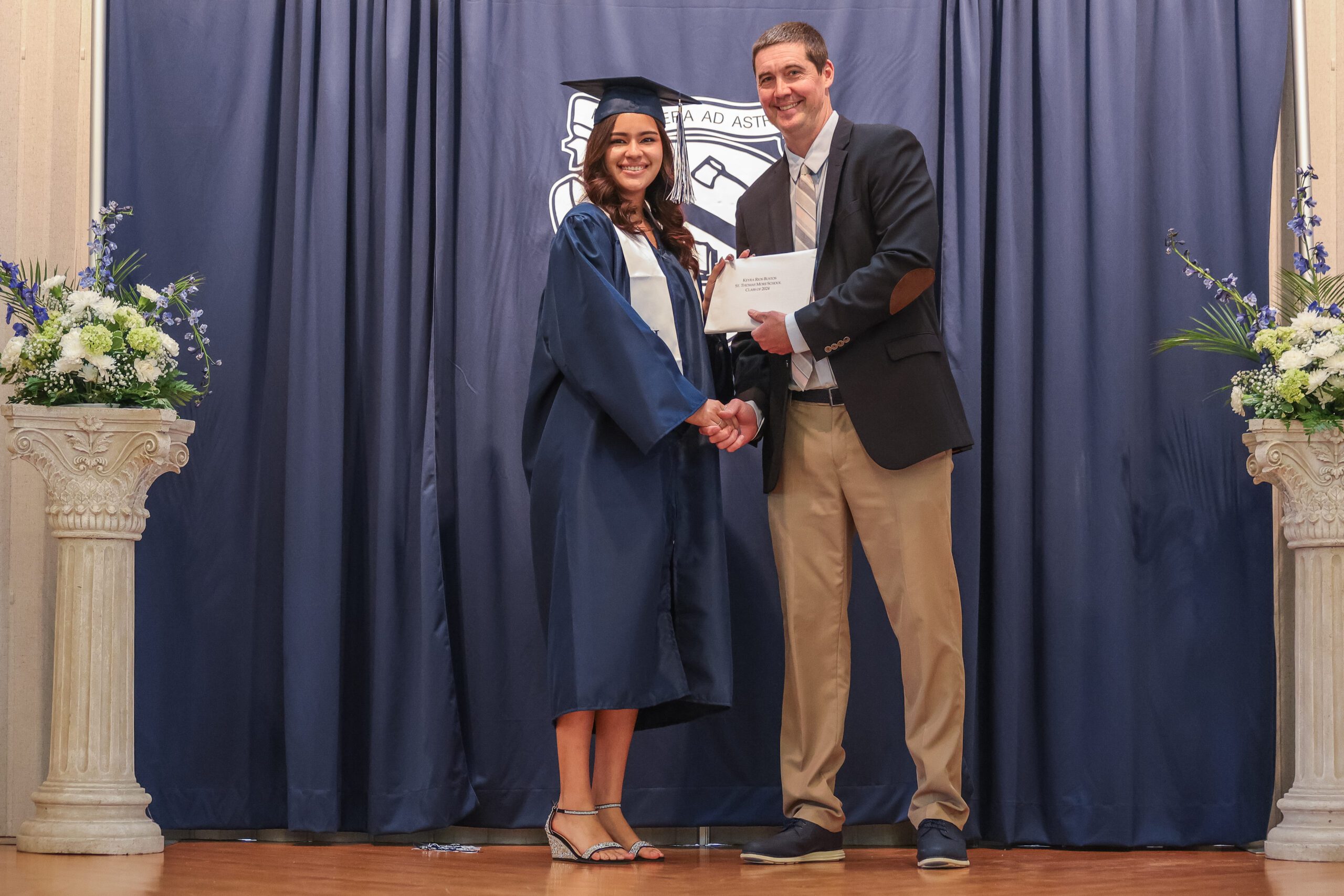 Head of School Awarding Diploma to Female Student at St. Thomas More (STM) Graduation